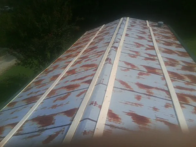 Rusted metal roof panels with new wood purlins before replacement — Storm Damage Roof Repair in Northport by Roofing Brothers